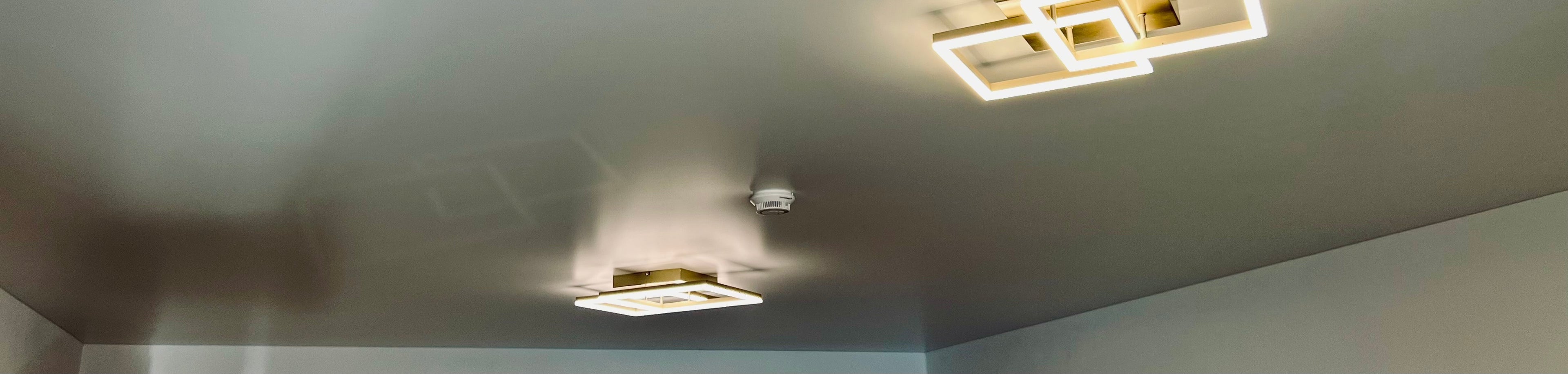 matt weiße Spanndecke im elegantem und modernen Stil mit zwei eingebauten Lichtern und Rauchmelder