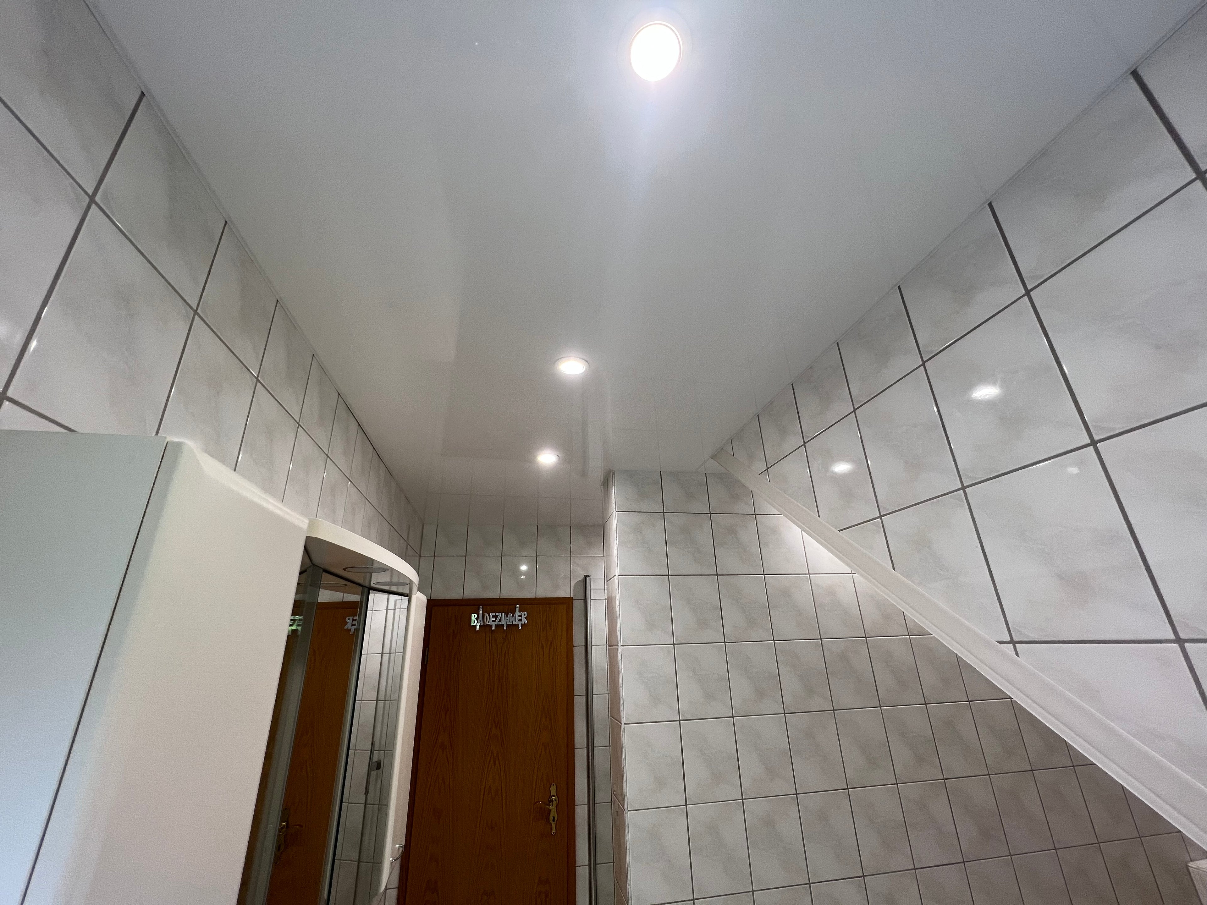 weiß glänzende Spanndecke im modernen Still im Bad mit integrierten Lichtern
